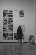 Woman viewing wall art prints arranged in a grid in a gallery setting showcasing printable art designs