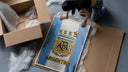 Argentina football national team crest jersey framed print being unpacked from protective bubble wrap and a box