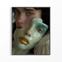 Close-up ceramic portrait with jade green glaze and metallic gold lips displayed in a dark frame on wall