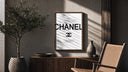 Chanel logo with quote poster framed above a fluted sideboard beside an olive tree