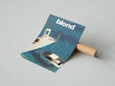 Frank Ocean Blond Album print displaying swimming pool scene set next to brown cardboard shipping tube