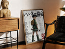 Brass-framed Anime boy with backpack and fishing rod print leaning in a warm styled corner by a sculpture