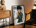 Brass-framed anime boy in fighting stance print leaning in a warm styled corner by a sculpture