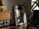 Walnut-framed anime boy in fighting stance print leaning against a sunlit rustic brick wall