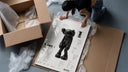 KAWS Companion Passing Through figure framed print being unpacked from protective bubble wrap and a box