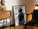 Brass-framed Man looking upward in profile print leaning in a warm styled corner by a sculpture