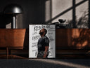 Black-framed Man looking upward in profile print on a moody console with designer coffee-table books