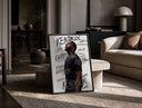 Man looking upward in profile print in a black frame leaning on a travertine table in a sunlit lounge
