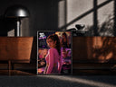 Black-framed Woman in pink top fan art print on a moody console with designer coffee-table books