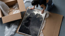 Long-haired warrior with armor on cliff framed print being unpacked from protective bubble wrap and a box