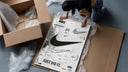 Nike Swoosh logo design study framed print being unpacked from protective bubble wrap and a box