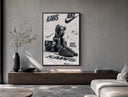KAWS Companion figure and sneaker poster framed above a wood console in a concrete-wall living room