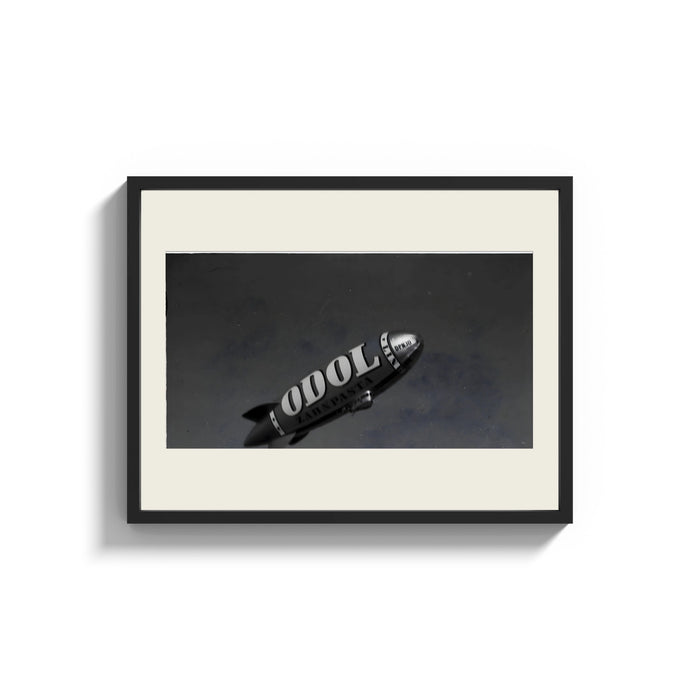 Framed advertising blimp airship print shown as a wide statement piece on a clean white wall