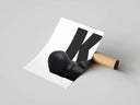 Rolled poster showing KAWS figure head and shoulders against large bold letter on white background