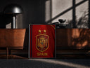 Black-framed Spain national football crest emblem print on a moody console with designer coffee-table books