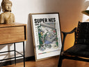 Brass-framed Super Nintendo game console with controller print leaning in a warm styled corner by a sculpture