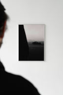White-framed Porsche 911 Midnight Drive print on white wall with silhouetted person visible in foreground