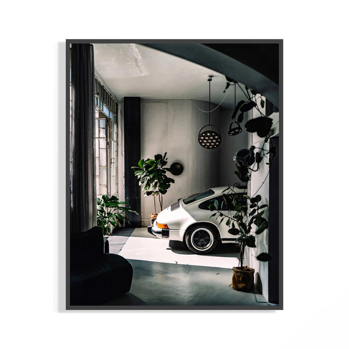 White Porsche 911 sports car parked in a modern industrial loft with concrete floors and pendant lights