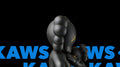 Black KAWS companion carrying a smaller companion over blue KAWS lettering — framed posters detail