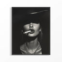Black and white 90s supermodel portrait with wide-brimmed hat and cigarette in dark frame on wall