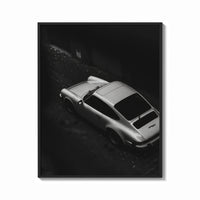 Framed Silver Porsche 911 parked in alley print shown as a bold statement piece on a clean gallery wall