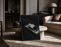 Silver Porsche 911 parked in alley print in a black frame leaning on a travertine table in a sunlit lounge