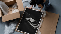 Silver Porsche 911 parked in alley framed print being unpacked from protective bubble wrap and a box
