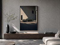 Vintage green Porsche 911 coupe poster framed above a wood console in a concrete-wall living room