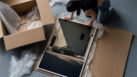 Vintage green Porsche 911 coupe framed print being unpacked from protective bubble wrap and a box