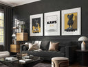 Contemporary Wall Art Set of 3 Posters with bold urban KAWS designs in black frames above sofa in modern living room — Haus of Prints