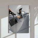 Elegant female leg in ripped jeans and high heels, with a designer bag in hand.