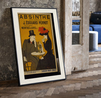 Man and woman drinking absinthe at table print in a black frame leaning beside a vintage door on parquet