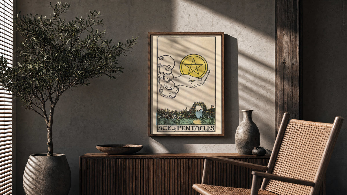 Ace of Pentacles poster framed above a fluted sideboard beside a potted tree