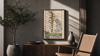 Ace of Wands poster framed above a fluted sideboard beside a potted tree