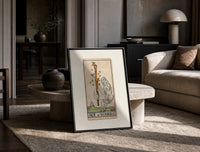 Hand holding sprouting wooden wand print in a black frame leaning on a travertine table in a sunlit lounge