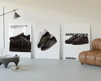 Air Jordan 1 Low Travis Scott three-panel set displayed beside a brown leather sofa