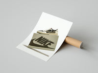 Person unrolling a white Nike poster featuring the Travis Scott Mocha Air Jordan 1 on a concrete floor
