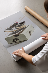 Unboxing a framed Air Jordan 1 Reverse Mocha artwork from cardboard packaging on a concrete floor