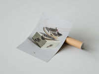 Woman unrolling a white Air Jordan 1 Reverse Mocha poster beside Nike boxes on a concrete floor