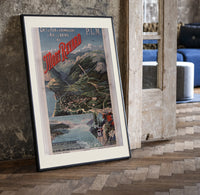 Alpine mountain and lake landscape print in a black frame leaning beside a vintage door on parquet