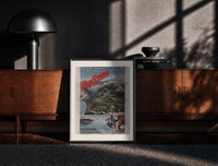 Black-framed Alpine mountain and lake landscape print on a moody console with designer coffee-table books