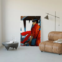 Red Akira Kaneda Jacket print leaning against a white wall beside a tan leather lounge chair