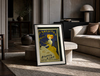 Woman in yellow eating biscuit print in a black frame leaning on a travertine table in a sunlit lounge