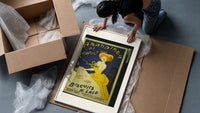 Woman in yellow eating biscuit framed print being unpacked from protective bubble wrap and a box