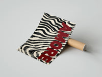 Gently curled Amore Zebra Print beside its protective shipping tube