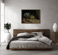 Apples and lemon in blue bowl print in a dark wood frame above a rattan bed on a plaster wall