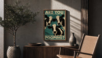 Are You Pooping Three Cows poster framed above a fluted sideboard beside a potted tree