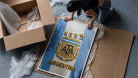 Argentina football national team crest jersey framed print being unpacked from protective bubble wrap and a box