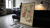 Woman with children playing indoors print in a slim black frame leaning on a dark sofa in a concrete print studio