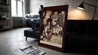 Old man and figures examining cloth print in a slim black frame leaning on a dark sofa in a concrete print studio